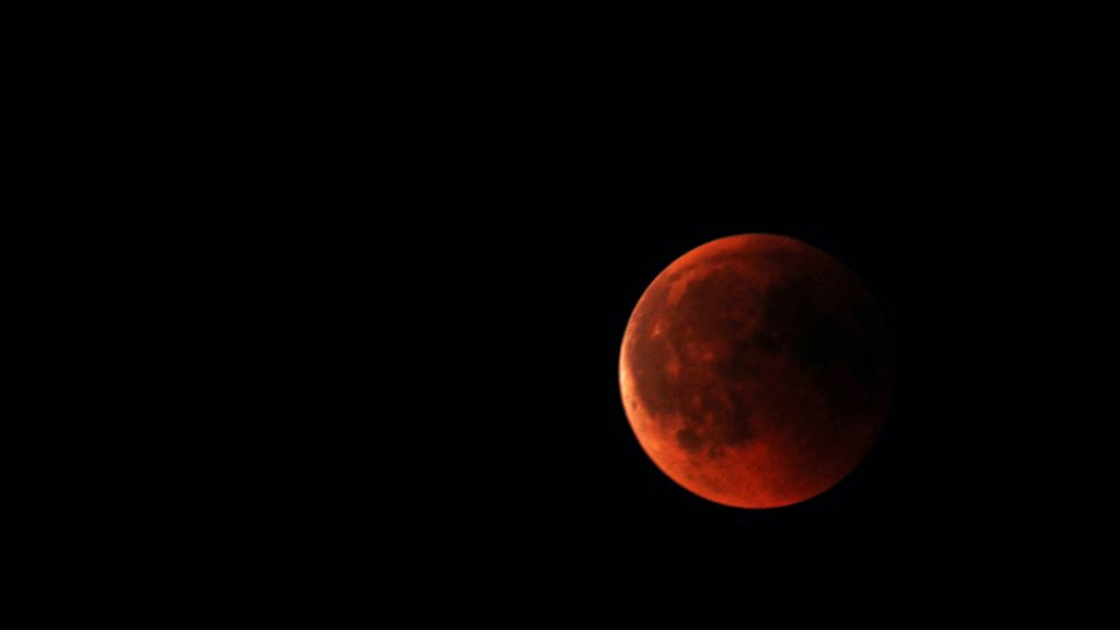 Image of full red moon in dark sky