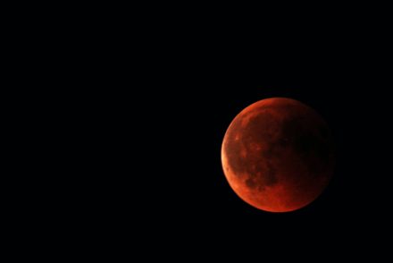 Image of full red moon in dark sky